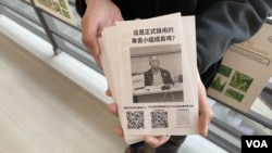 中大四年级学生徐同学2月25日在校友评议会周年大会场外派发传单，呼吁参与网上联署，反对有3名立法会议员提出的改组中大校董会议案 (美国之音/汤惠芸)