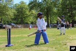 FILE - Akash Khargie, 8, left, learns proper bat holding and wicket position during a practice at Eisenhower Park in East Meadow, New York, May 11, 2024. (AP Photo/Phil Marcelo)