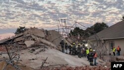 Waokoaji wakiwa katika eneo la jengo lililoporomoka huko George, Mei 7, 2024. Willie van Tonder / AFP. 