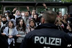 Protesters face German police officers during a pro-Palestinians demonstration by the group "Student Coalition Berlin" at the 'Freie Universität Berlin' in Berlin, Germany, Tuesday, May 7, 2024. (AP Photo/Markus Schreiber)