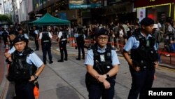 资料照片：2023年6月4日，1989年北京天安门广场镇压34周年之际，中国香港警察在市中心待命，附近是以往通常举行烛光守夜活动的场所。
近日，警方和大学当局阻止学生举行纪念雨伞运动的守夜活动，甚至在10月1日逮捕了一名在公共场合手持白花的男子。（路透社图片）