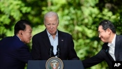 조 바이든 미국 대통령과 윤석열 한국 대통령, 기시다 후미오 일본 총리가 지난해 8월18일 캠프 데이비드에서 정상회의에 이어 공동 회견을 했다. 윤 대통령과 기시다 총리가 회의장에서 악수를 나누고 있다.