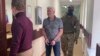 FILE - In this handout photo taken from video released by Lefortovo District Court, Robert Shonov walks to the courtroom at the Lefortovo District Court in Moscow, May 18, 2023.