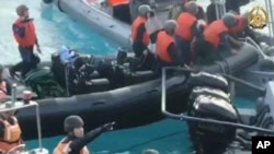 在菲律宾武装部队提供的这张图片中，中国海警手持刀具和砍刀，向在有争议的南中国海第二托马斯浅滩(中国称仁爱礁)执行补给任务的菲律宾军队靠近。(2024年6月17日)