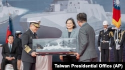 台湾总统蔡英文在宜兰苏澳商港主持“安江军舰”和“万江军舰”交付仪式时接受舰船模型。（2024年3月26日）