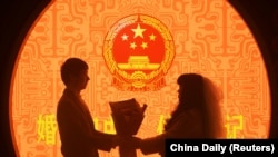 中国浙江省杭州市婚姻登记处的一对新人在情人节登记结婚。（2023年2月14日）