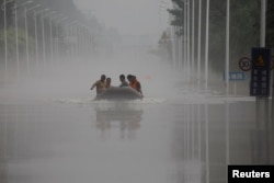 中国河北涿州民众在滔滔洪水中乘坐橡皮艇逃生。（2023年8月3日）