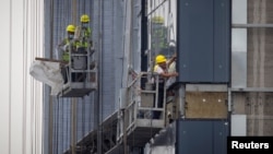 资料照：中国工人在北京的一处住宅楼工地施工。（2023年7月29日）