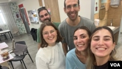 来自德国的志工，Maria (前排左1）在10月24日因以哈战争而需返回德国前到SHEKEL 的Sigaliyot 智障老人日照中心与日照中心员工合照留念。(美国之音 赖素芬)