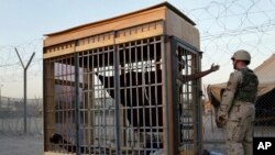 Zatvorenik u samici na otvorenom u Abu Graibu, na periferiji Iraka, 22. juna 2004. (Foto: AP Photo/John Moore)