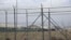 FILE - A hangar can be seen behind barbed wire fencing at Bagram Air Base after the U.S. military left the facility, in Parwan province, north of Kabul, Afghanistan, July 5, 2021.