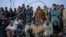 FILE - Afghan refugees wait to register in a camp near the Torkham Pakistan-Afghanistan border in Torkham, Afghanistan, Nov. 4, 2023. 