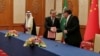 Iranian security council official Ali Shamkhani shakes hands with China's senior foreign policy official Wang Yi as Saudi security adviser Musaad bin Mohammed al-Aiban watches during a signing of an accord to reset Iranian-Saudi ties, in Beijing, March 10, 2023. (Nournews via AP)