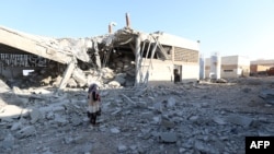 সিরিয়ার বিদ্রোহী-নিয়ন্ত্রিত উত্তর-পশ্চিম এলাকায় একটি পরিত্যক্ত পানির পাম্পিং স্টেশনে রাশিয়ার বিমান হামলার পর ধ্বংসাবশেষের মধ্যে দাঁড়িয়ে আছে একটি মেয়ে। ২৩ অগাস্ট ২০২৩