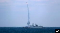 资料照片：中国海军护卫舰滨州号2022年12月27日在东中国海参加与俄罗斯军舰的联合海军演习。（美联社照片）