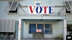 Foto Achiv: Yon banye ki di "Vote" sou yon bilding nan Fort Myers Beach, Florid, jounen eleksyon an, 8 Nov. 2022. 