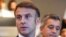 France's President Emmanuel Macron (L) gives a speech next to France's outgoing Minister for Interior and Overseas Gerald Darmanin (R) as they meet French police officers during the Paris 2024 Olympic Games in Paris, July 27, 2024.