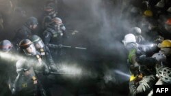 Police face pro-Palestinian students after destroying part of the encampment on the campus of the University of California, Los Angeles (UCLA) in Los Angeles, California, early on May 2, 2024. (Photo by Etienne LAURENT / AFP)
