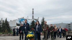 乌克兰切尔诺贝利核电站的工作人员向切尔诺贝利核事故罹难者纪念碑献花。（2023年4月26日）