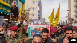 অনার গার্ডরা ইরাকের পবিত্র শহর নাজাফের ইমাম আলীর মাজারে রাজি মুসাভির অন্ত্যোষ্টিক্রিয়ার সময় তার কফিন বহন করছে। ২৭ ডিসেম্বর, ২০২৩। 