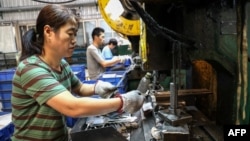 中国山东省滨州市一家餐具厂的工人在生产线上做工。(2024年7月24日)