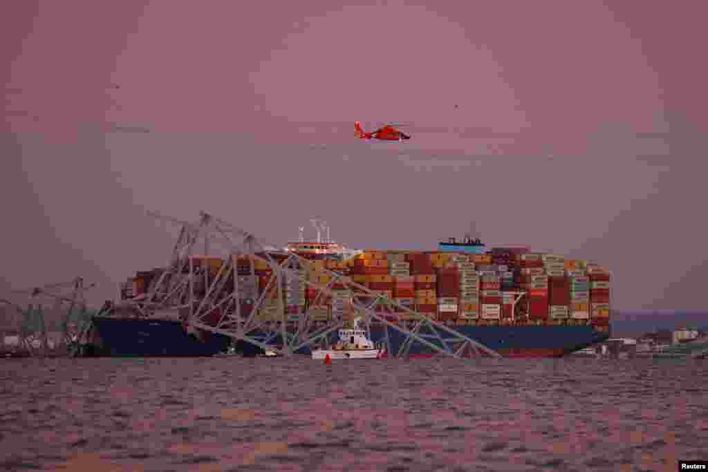 Хеликоптер лета над локацијата каде товарниот брод удри во мостот Френсис Скот Ки во Балтимор, Мериленд, 26 март 2024 година.