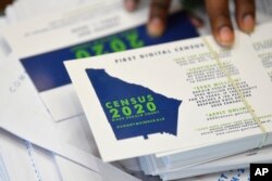 In this Aug. 13, 2019, file photo a worker gets ready to pass out instructions on how to fill out the 2020 census during a town hall meeting in Lithonia, Ga. (AP Photo/John Amis, File)