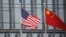 বেইজিংয়ে একটি আমেরিকান কোম্পানির ভবনের বাইরে চীন ও আমেরিকার পতাকা উড়ছে। ছবিঃ ২১ জানুয়ারী, ২০২১ 