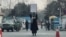FILE - A young woman protests alone against a Taliban ban on women's higher education, outside Kabul University, as Taliban guards stand by, in Kabul, Afghanistan, Dec. 25, 2022. 