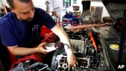 FILE - Andre Monteiro works on a car at Wilder Brothers American Car Care Center in Scituate, Mass. Massachusetts voters approved a right-to-repair initiative in 2020. Now, the Biden administration is pushing federal legislation on the same topic. 
