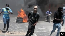 ຜູ້​ປ​ະ​ທ້ວງ​ແລ່ນ​ຫາ​ບ່ອນ​ຄຸ້ມ​ກັນ​ຈາກ​ແກັ​ສ​ນ້ຳ​ຕາ​ທີ່​ຖືກ​ຍິງ​ໃສ່​ໂດ​ຍ​ຕຳຫຼວດ ໃນ​ລະ​ຫວ່າງ​ການ​ປະ​ທ້ວງ​ຕໍ່​ຕ້ານ​ຄວາມບໍ່​ໝັ້ນ​ຄົງ​ໃນ​ນະ​ຄອນຫຼວງ ປອກ-​ໂອ-​ແປ​ຣງ, ເຮ​ຕີ, 7 ສິງ​ຫາ 2023.