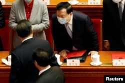 资料照：中共中央港澳办主任夏宝龙在全国人大会议上与中国领导人习近平交流。（2022年3月11日）