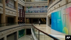 一名男子在北京一家空荡荡的商场里走路。(2023年7月27日)