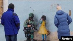 Каква било закана, па дури и употреба на нуклеарно оружје нема да ги смени нашите стремежи за слобода и за независност, вели Володимир Лиашченко, кој со своето семејство останал во Киев уште од почетоците на руската инвазија. (UKRAINE-CRISIS/ARTWORKS)