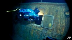 In this image from the Woods Hole Oceanographic Institution, an underwater remote vehicle examines an open window of the Titanic in 1986.