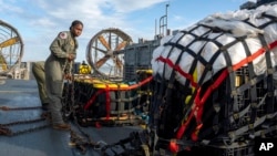 在美国海军发布的这张图片中，美国海军人员2023年2月10日准备将在南卡罗来纳州默特尔海滩（Myrtle Beach）海岸附近寻回的材料运往联邦调查局，这些材料是从中国高空气球被击落后回收的。