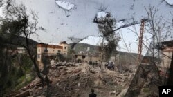 የእስራኤል የአየር ጥቃት ባደረሰው ጉዳት የአካባቢው ሰዎች ፍርስራሽ አካባቢ ተሰባስበው ደቡብ ሊባኖስ፣ በሄባሪዬ መንደር፣ እአአ መጋቢት 27/2024