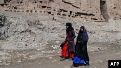 FILE - Afghan women walk near the site of the Buddhas of Bamiyan statues, which were destroyed by the Taliban in 2001, in Bamiyan province, Afghanistan, March 7, 2024. Bamiyan is the site of a gun attack on Western tourists on May 17, 2024.