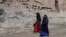 FILE - Afghan women walk near the site of the Buddhas of Bamiyan statues, which were destroyed by the Taliban in 2001, in Bamiyan province, Afghanistan, March 7, 2024. Bamiyan is the site of a gun attack on Western tourists on May 17, 2024.