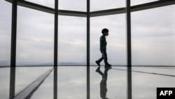 一个孩子走在韩国首尔乐天世界塔123层高的观景台玻璃地板上。（2022年5月13日）