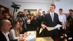 Градоначалникот на Истанбул и Републиканската народна партија Екрем Имамоглу, држи гласачко ливче пред да гласа на избирачко место во Истанбул, Турција, 31 март 2024 година.