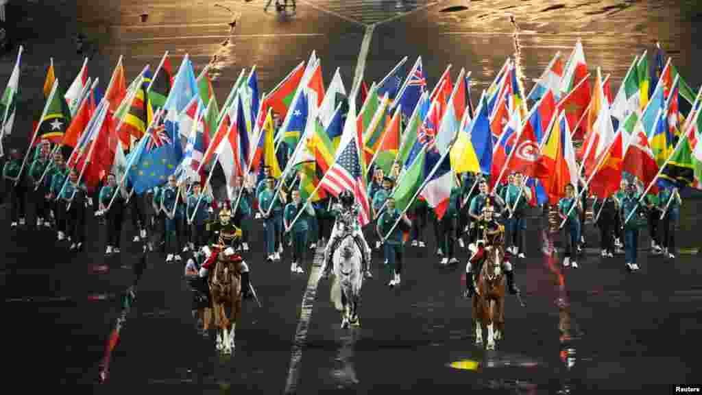 Bendera Olimpiade dibawa ke Trocadero oleh Floriane Issert, tengah, saat upacara pembukaan Olimpiade Musim Panas Paris 2024 di sepanjang Sungai Seine, 26 Juli 2024. (Rob Schumacher/USA Today Sports)