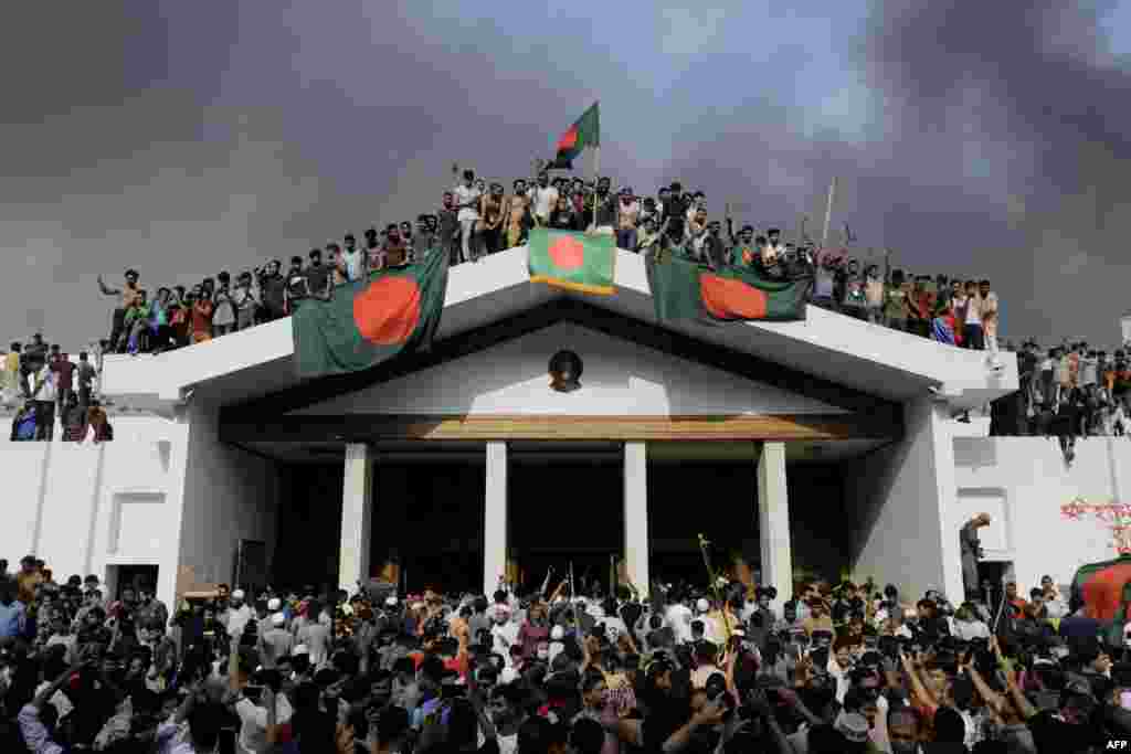 Anti-government protesters display Bangladesh&#39;s national flag as they storm Prime Minister Sheikh Hasina&#39;s palace in Dhaka, Aug. 5, 2024. Bangladesh army chief Waker-Uz-Zaman spent nearly four decades rising to the top of the military and said he was &quot;taking full responsibility&quot; after Prime Minister Sheikh Hasina was ousted and fled.