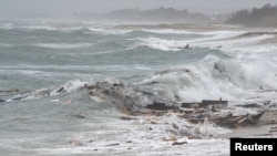 一艘装载移民的船只周日(2月26日)早些时候在意大利南部海岸附近撞上礁石，造成43人死亡。照片显示被海浪冲上海滩的遇难船只残骸。