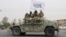 FILE - Taliban fighters patrol on the road during a celebration marking the second anniversary of the withdrawal of US-led troops from Afghanistan, in Kandahar, south of Kabul, Aug. 15, 2023. 