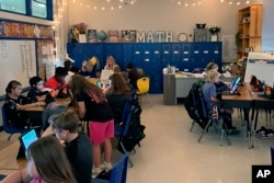Piedmont Elementary School math teacher Cassie Holbrooks works with a small group of fourth grade students in Piedmont, Ala., on Thursday, Aug. 31, 2023. The rest of her class is working independently. (Trisha Powell Crain/AL.com via AP)