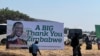 People walk past a ruling Zanu PF poster thanking Zimbabweans for voting for President Emmerson Mnangagwa, in Harare, Sept. 4, 2023. (Columbus Mavhunga/VOA)