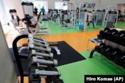 At a gym, you can use free weights (seen in the foreground) or weight machines (seen in the background.) People work out at the Fukagawa Sports Center in Tokyo, Wednesday, June 12, 2024. (AP Photo/Hiro Komae)