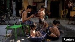 Children sit in buckets and basins during a hot day in Manila, Philippines, April 29, 2024. (REUTERS/Eloisa Lopez)