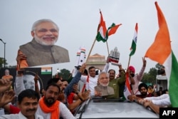 印度民众在新德里挥舞国旗和总理莫迪画像庆祝印度“月船3号”太空探测器星期三（8月23日）成功在月球南极表面软着陆。